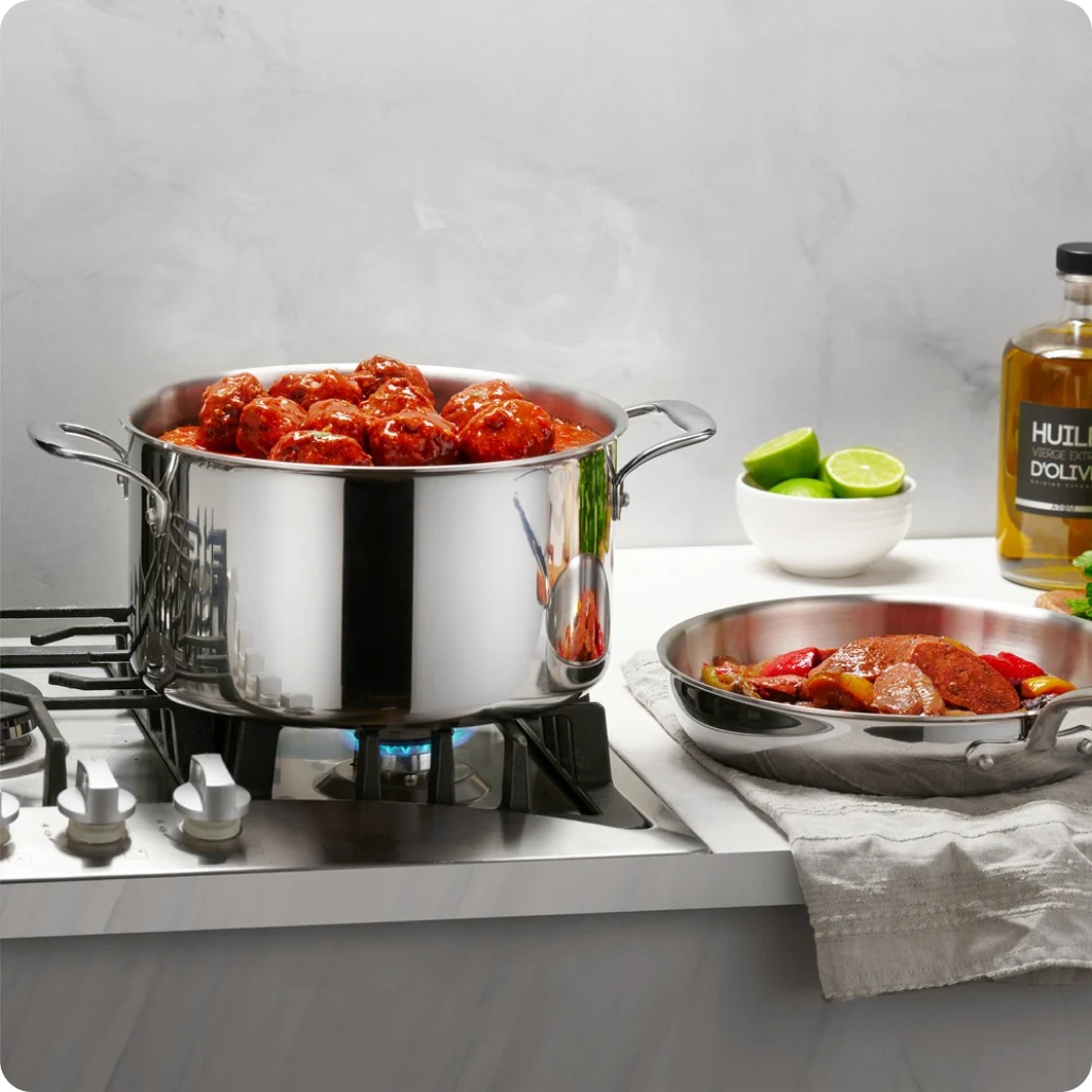 Meatballs simmering in a Legend stockpot on a gas stove